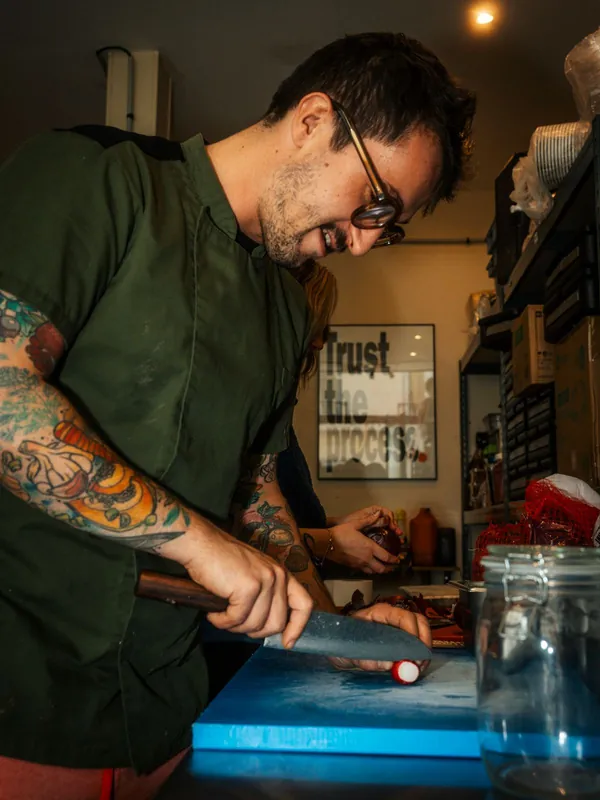Un chef tatoué découpe en cuisine