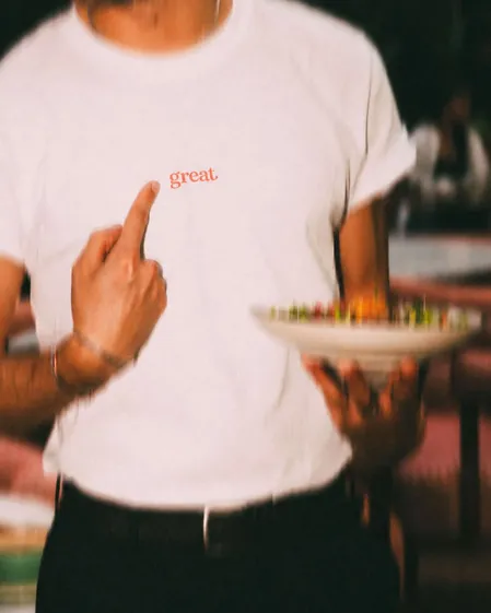 Un serveur Great en t-shirt blanc, assiette à la main