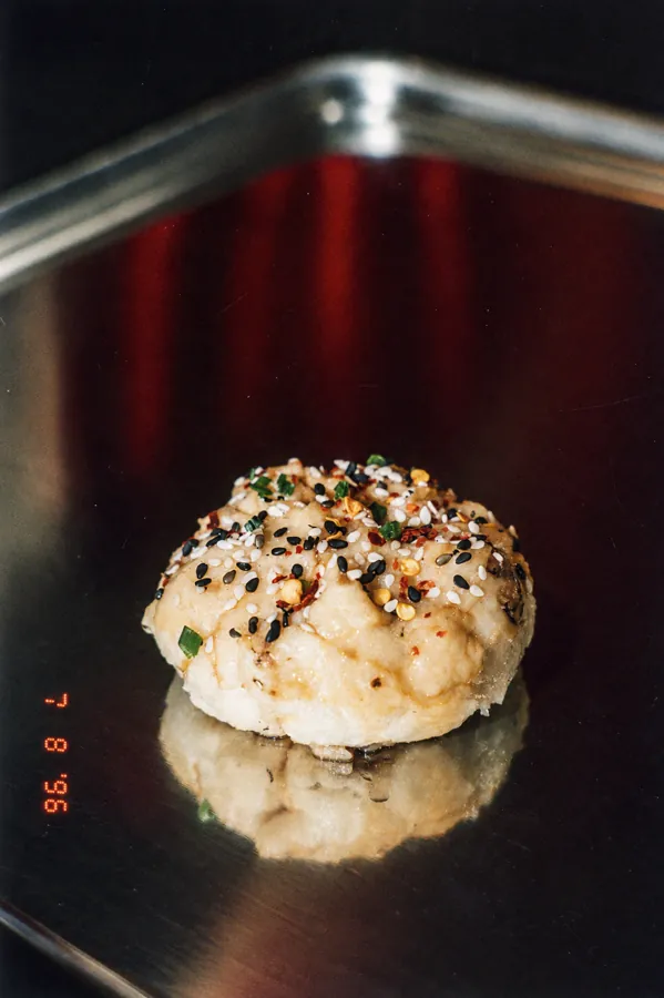 Bao poêlé au sésame et piment sur un plateau inox