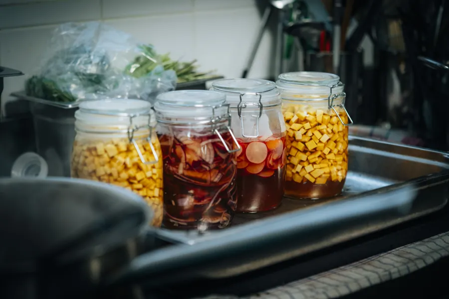Bocaux de pickles maison : oignons rouges, radis et légumes en cubes