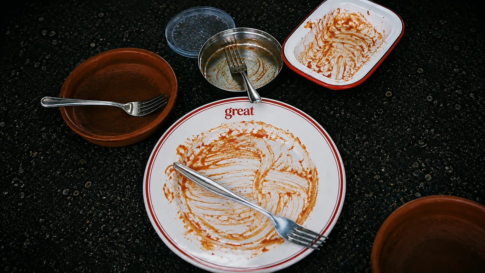 Assiettes et plats vides, saucés jusqu'au bout, sur une table
