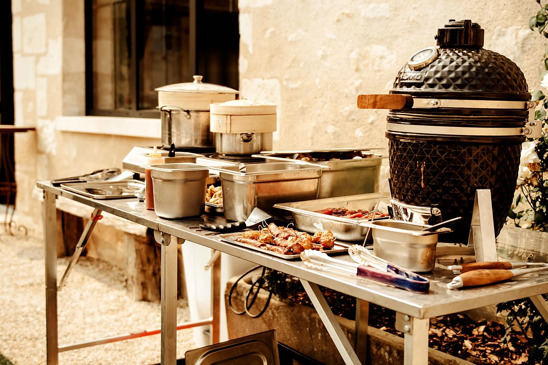 Table de service Great en extérieur : barbecue kamado, brochettes grillées, paniers vapeur et bacs inox